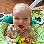 Joseph joined the competition — help win amazing prizes! baby, smiling, toy, indoor, child, seat, colorful, happy, face, clothing, floor, patterned_rug, padded_seat, hand, cute, infant, play, bright_eyes, furniture, comfort