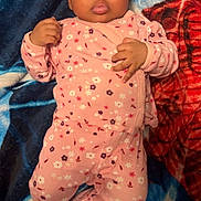 Kinnlaya is registered to the contest to win money with this photo: baby, infant, child, pajamas, pink_clothing, floral_pattern, curly_hair, blanket, blue_blanket, red_blanket, lying_down, indoors, cute, face, hands, footed_pajamas, adorable, portrait, young_child, cozy