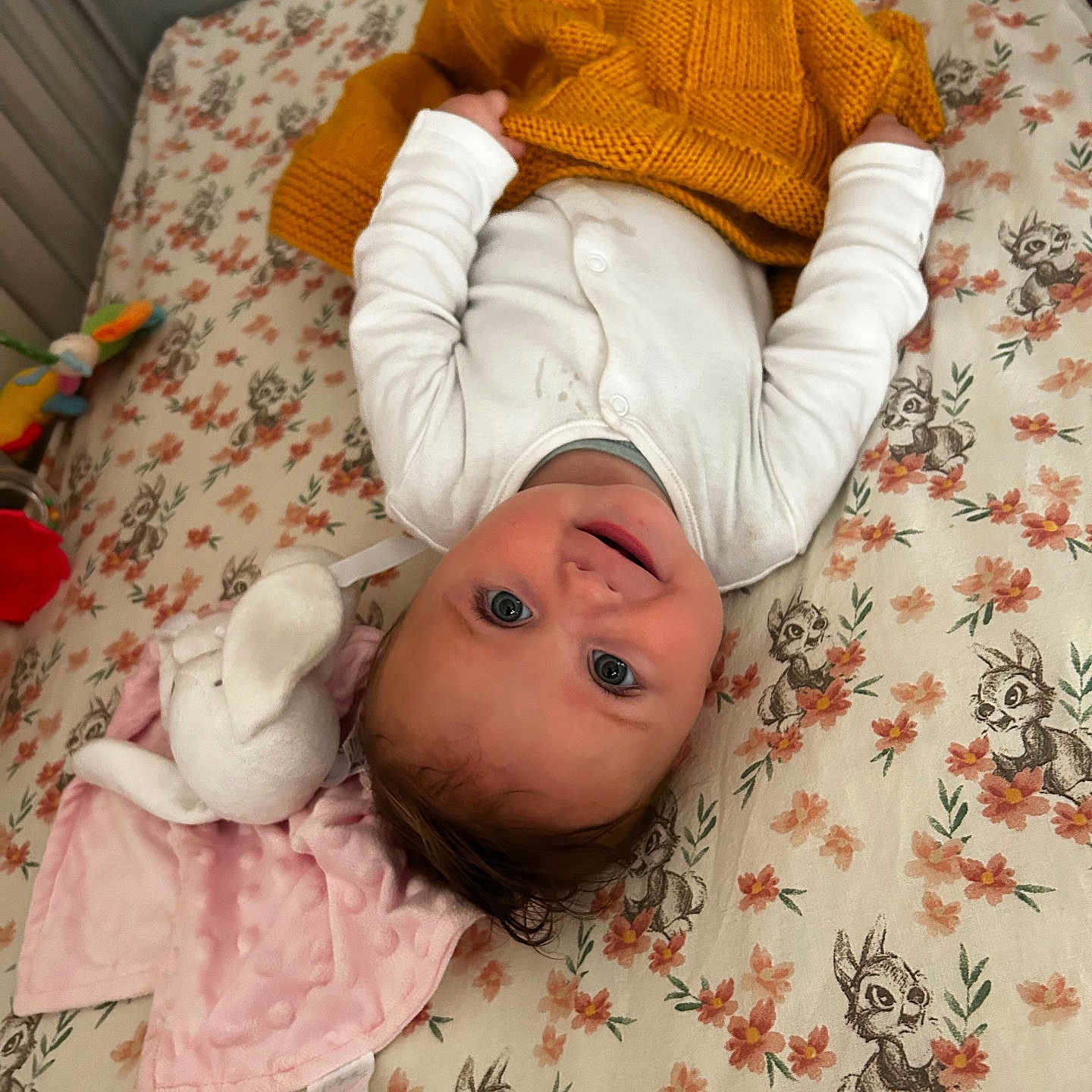 Alice joined the competition — help win amazing prizes! baby, bed, blanket, child, cozy, cute, face, floral_pattern, happy, head, indoors, infant, lying_down, person, pink_blanket, plush_toy, smiling, soft_toy, white_clothing, yellow_blanket