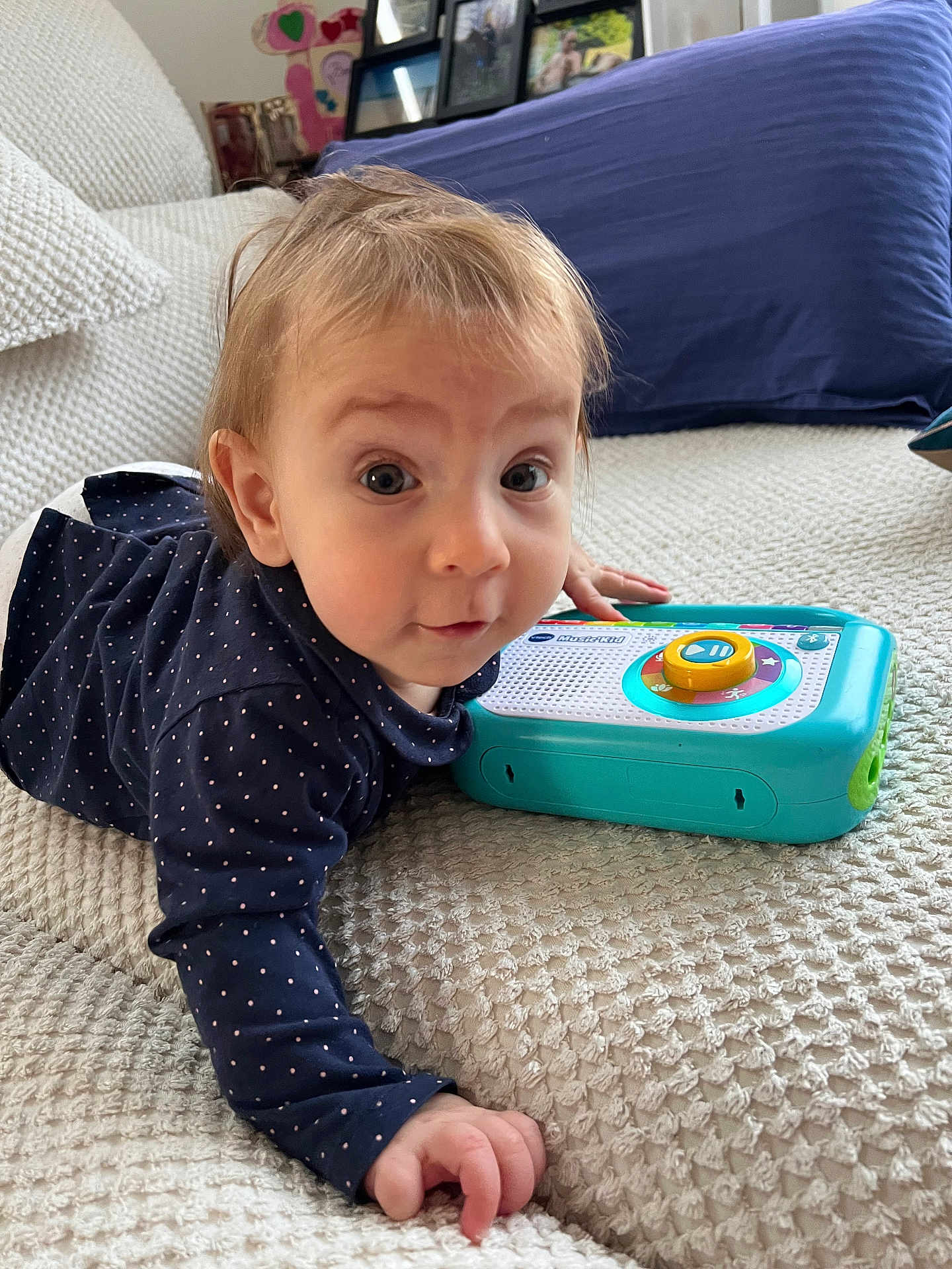 Leonie a rejoint le concours — aidez-le/la à gagner de superbes lots ! baby, child, infant, toy, polka_dot, navy_clothing, blanket, couch, indoor, curious, face, hand, play, texture, portrait, person, home, furniture, expression, toddler
