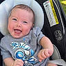 baby, smiling, toddler, car_seat, astronaut_tshirt, happy, infant, outdoor, clothing, seat, child, cute, person, head, face, skin, expression, baby_girl, baby_boy, daylight
