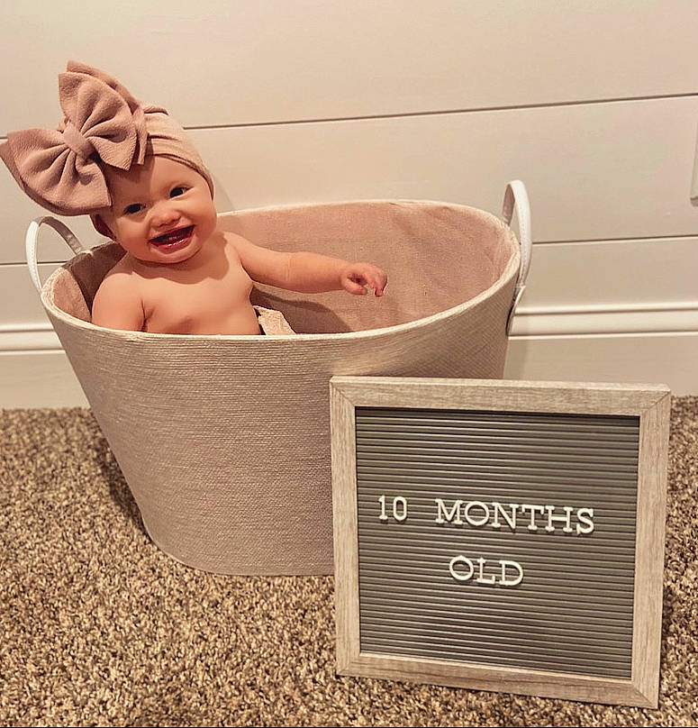 Juliette is registered to the contest to win money with this photo: baby, baby_bathing, bathing, bathtub, beige, child, headwear, joy, person, pink, product, rectangle, room, toddler
