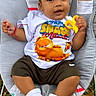 baby, child, infant, outdoor, grass, baby_seat, toy, banana_toy, garfield_tshirt, white_socks, shorts, cute, smiling, portrait, young_child, casual_clothing, colorful, playful, relaxed, person