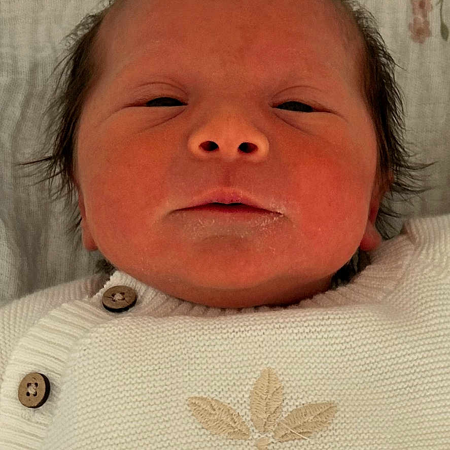 Kataleya a rejoint le concours — aidez-le/la à gagner de superbes lots ! newborn, baby, infant, face, portrait, white_clothing, knitwear, buttons, lying_down, blanket, floral_pattern, skin, head, sleepy, indoors, closeup, baby_face, person, baby_garment, portrait_mode
