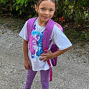 Sophia joined the competition — help win amazing prizes! child, girl, backpack, purple, leggings, tshirt, cartoon, outdoor, gravel, smile, standing, nature, greenery, casual_clothing, footwear, confident, young, playful, portrait, person
