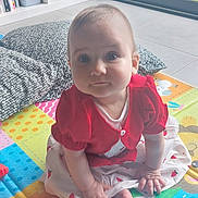 Elsa a rejoint le concours — aidez-le/la à gagner de superbes lots ! baby, cardigan, child, colorful, cushion, cute, dress, expression, face, floor, foot, hand, home, indoor, light, person, playmat, sitting, toy, window