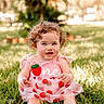 Ava is registered to the contest to win money with this photo: toddler, child, grass, outdoor, sunlight, curly_hair, pink_dress, strawberry_pattern, smiling, sitting, nature, portrait, happy, baby, greenery, daylight, cute, one_year_old, summer, park