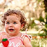 Ava joined the competition — help win amazing prizes! toddler, child, curly_hair, blue_eyes, pink_dress, strawberry_pattern, outdoor, grass, sunlight, portrait, baby, cute, smiling, nature, summer, happy, sitting, young_child, closeup, daylight