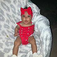 Zariah is registered to the contest to win money with this photo: baby, infant, child, portrait, red_bow, red_outfit, heart_pattern, blanket, fluffy_blanket, socks, sitting, lying_down, wide_eyes, outdoor, night, flash_photography, close_up, adorable, casual_photo, family_photo