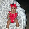baby, infant, child, portrait, red_bow, red_outfit, heart_pattern, blanket, fluffy_blanket, socks, sitting, lying_down, wide_eyes, outdoor, night, flash_photography, close_up, adorable, casual_photo, family_photo