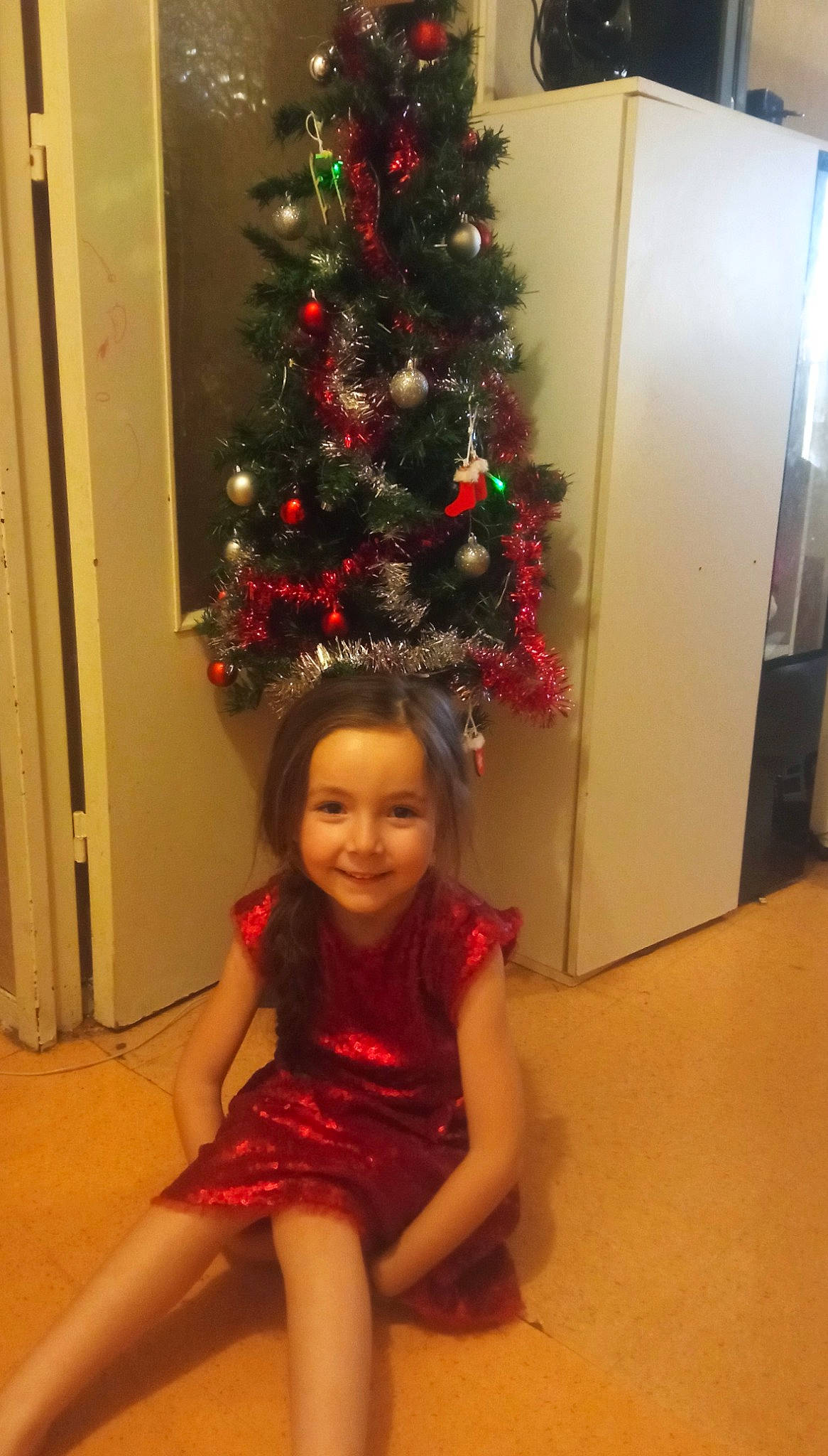 Célia participe au concours pour gagner de l'argent avec cette photo : beauty, christmas, christmas_decoration, christmas_ornament, christmas_tree, dress, event, evergreen, flooring, fun, happy, holiday_ornament, human_body, joy, ornament, person, red, smile, standing, thigh