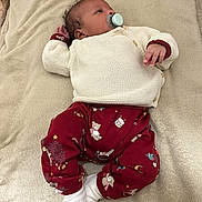 Lyam participe au concours pour gagner de l'argent avec cette photo : baby, infant, pacifier, clothing, blanket, red_pants, knit_sweater, teddy_bear_pattern, white_socks, lying_down, indoor, soft_texture, cute, child, young, peaceful, small_hand, face, head, relaxed