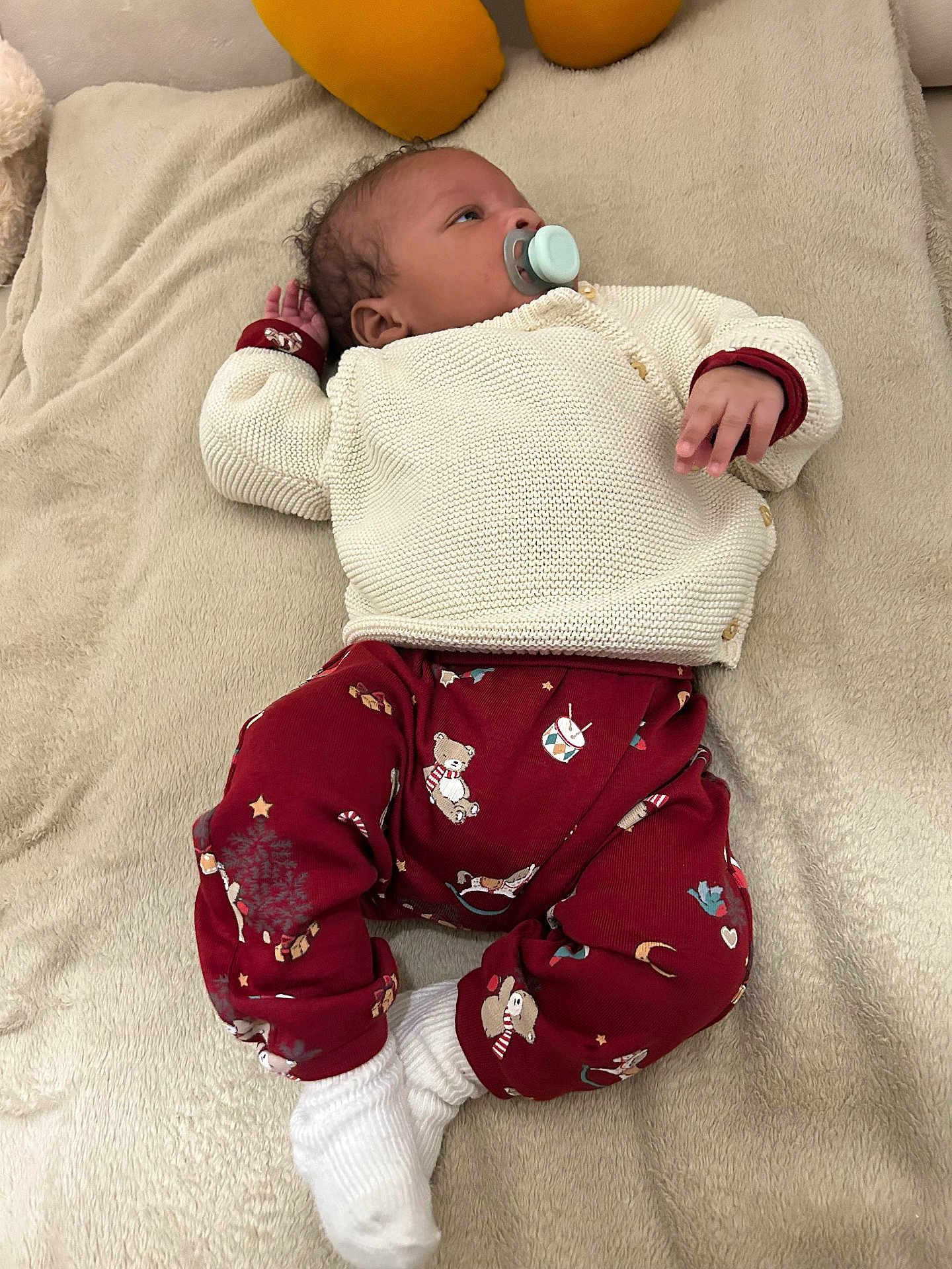 Lyam participe au concours pour gagner de l'argent avec cette photo : baby, infant, pacifier, clothing, blanket, red_pants, knit_sweater, teddy_bear_pattern, white_socks, lying_down, indoor, soft_texture, cute, child, young, peaceful, small_hand, face, head, relaxed