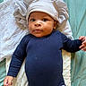 baby, bedding, blanket, blue_clothing, child, cute, eyes, face, hands, hat, indoors, infant, lying_down, neutral_expression, newborn, onesie, pillow, portrait, skin, soft_texture