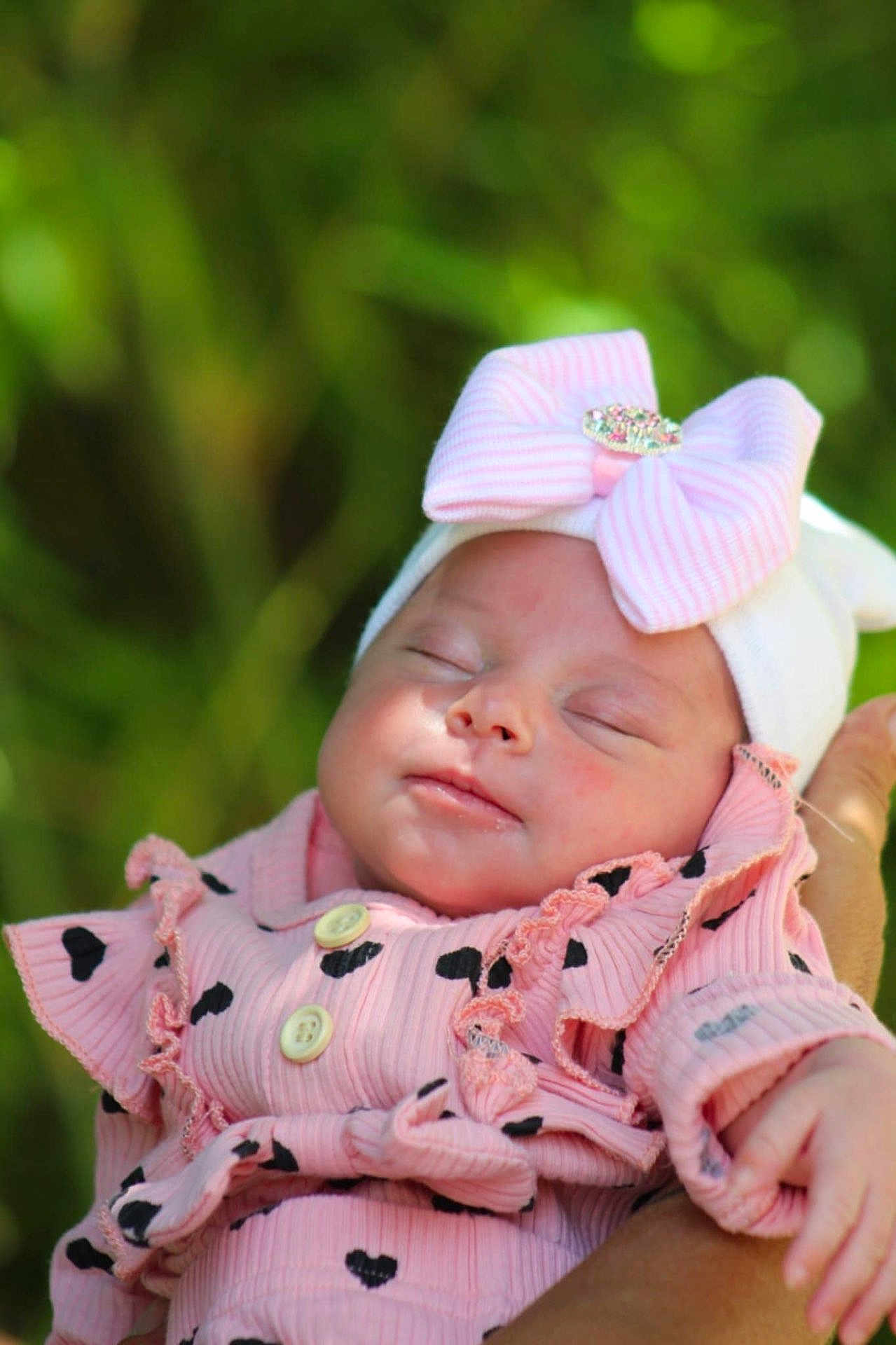 Jayna a rejoint le concours — aidez-le/la à gagner de superbes lots ! adorable, baby, bow, child, close_up, cute, hand, headband, heart_pattern, human, infant, nature_background, newborn, outdoor, peaceful, pink_outfit, portrait, resting, sleeping, soft_lighting