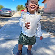 Lilyanna joined the competition — help win amazing prizes! casual_clothing, child, cute, daylight, fashion, green_skirt, hair_buns, happy, outdoor, person, portrait, purple_boots, sidewalk, smiling, standing, sunny, toddler, urban_background, white_sweater, young_child