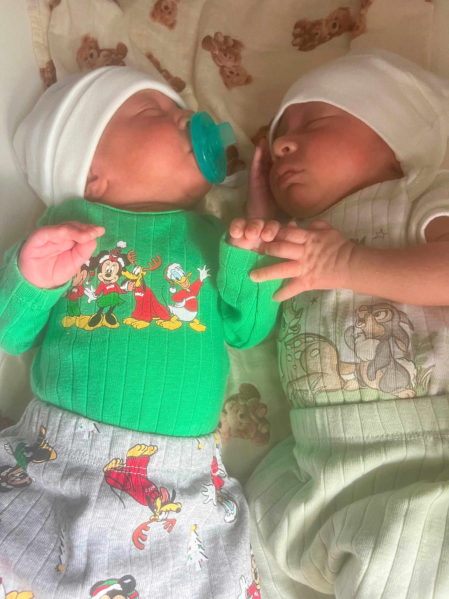 Jayden And Aiden is registered to the contest to win money with this photo: baby, bed, cartoon_clothing, child, cozy, cute, green_sweater, hand_holding, hat, indoors, infant, newborn, pacifier, peaceful, portrait, sleeping, soft_lighting, striped_pants, teddy_bear_blanket, two_babies