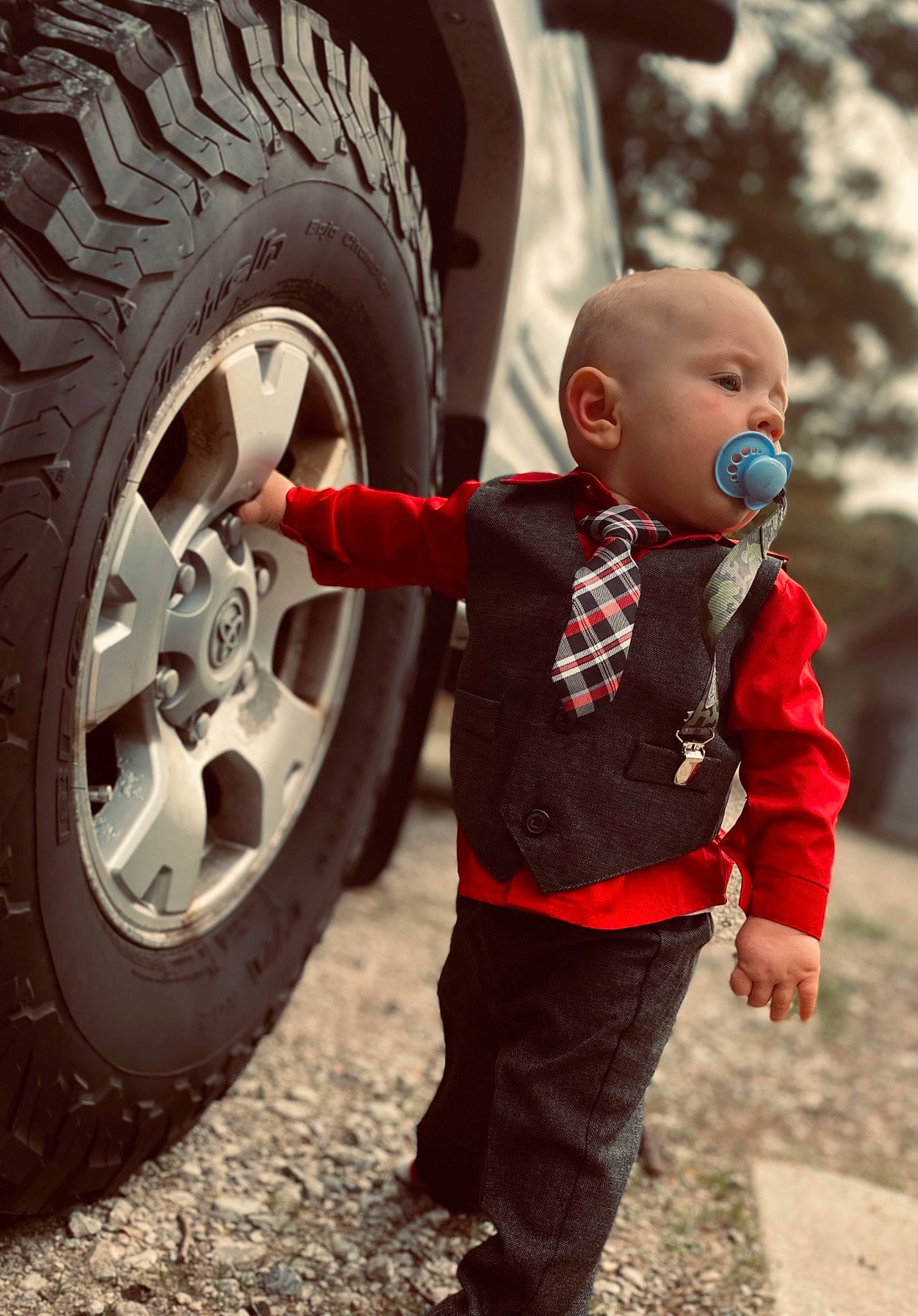 Remington is registered to the contest to win money with this photo: alloy_wheel, automotive_design, automotive_exterior, automotive_tire, automotive_wheel_system, baby, car, fender, happy, hubcap, motor_vehicle, person, rim, spoke, synthetic_rubber, tire, tire_care, toddler, tread, vehicle