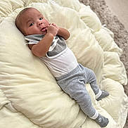 Reshard joined the competition — help win amazing prizes! baby, infant, cushion, blanket, clothing, grey, white, socks, hand, face, lying_down, carpet, soft, cute, child, person, indoors, portrait, comfort, cozy