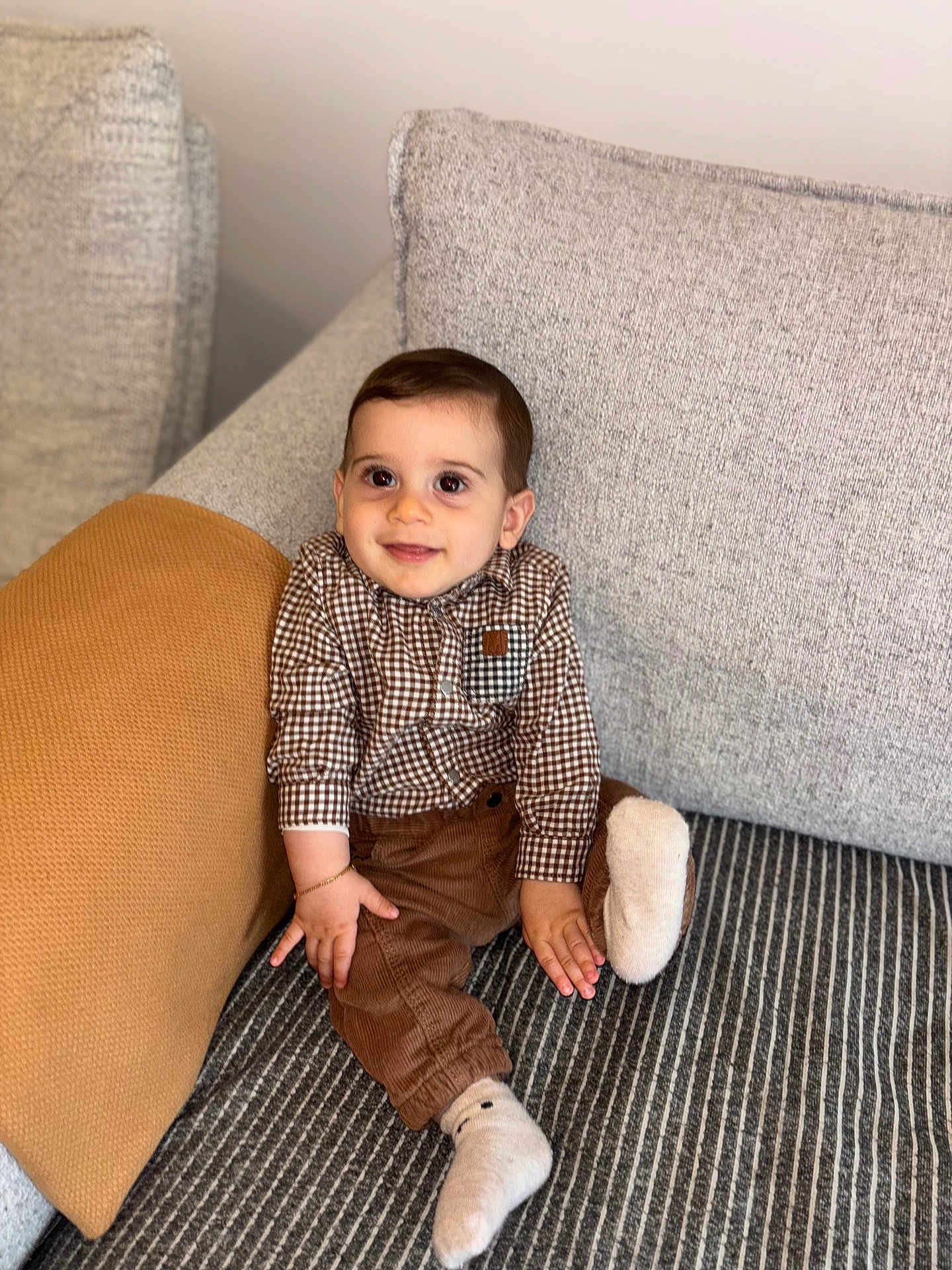 Loris participe au concours pour gagner de l'argent avec cette photo : baby, child, smiling, sitting, couch, pillow, clothing, shirt, pants, socks, indoor, home, portrait, cute, young_child, happy, furniture, cozy, infant, person