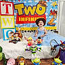 Madison is registered to the contest to win money with this photo: child, toddler, birthday, toy_story, toys, cowboy_hat, blue_dress, mr_potato_head, buzz_lightyear, woody, jessie, rex_dinosaur, alien_toys, birthday_banner, blocks, smiling, indoors, celebration, curtains, white_bed