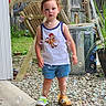 toddler, child, outdoor, bubbles, soap_bubbles, grass, wooden_chair, fence, plant, pot, trash_can, shorts, tank_top, footwear, curly_hair, expression, sidewalk, gravel, summer, playful