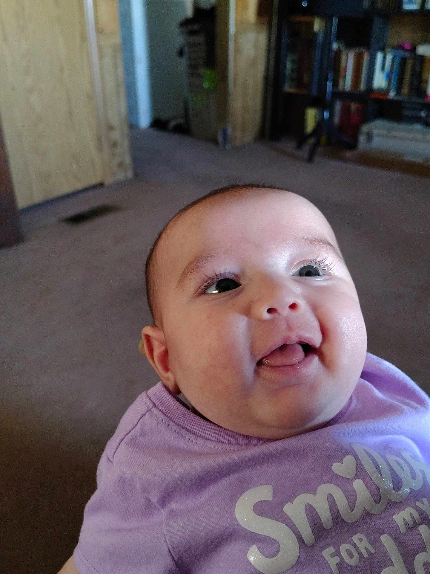 Harvest joined the competition — help win amazing prizes! baby, child, smiling, tongue_out, purple_shirt, indoor, carpet, bookshelf, furniture, face, head, happy, person, young_child, cute, expression, clothing, room, light, portrait