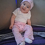 Harvest joined the competition — help win amazing prizes! child, baby, infant, smiling, pink_hat, onesie, pink_pants, socks, couch, blanket, sitting, portrait, face, head, happy, cozy, indoor, furniture, patterned_blanket, casual_clothing