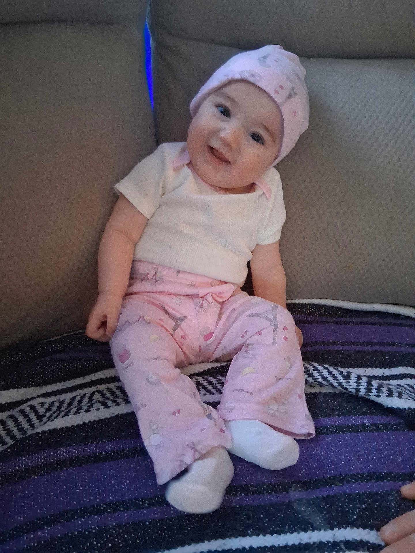Harvest joined the competition — help win amazing prizes! child, baby, infant, smiling, pink_hat, onesie, pink_pants, socks, couch, blanket, sitting, portrait, face, head, happy, cozy, indoor, furniture, patterned_blanket, casual_clothing