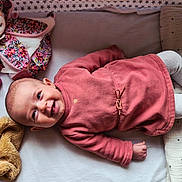 Louisa a rejoint le concours — aidez-le/la à gagner de superbes lots ! baby, infant, smiling, lying_down, pink_clothing, stuffed_animal, pacifier, bedding, stars_pattern, toddler, cute, child, soft_toys, blanket, indoors, happy, face, head, sleep_area, cozy