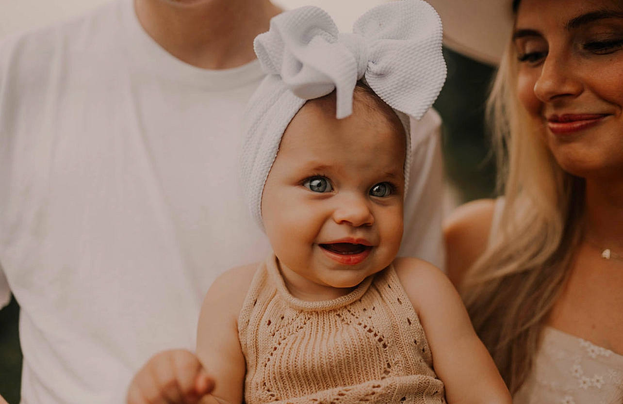 Lily is registered to the contest to win money with this photo: baby, baby_toddler_clothing, chin, eye, eyelash, face, fashion, flash_photography, gesture, happy, head, headwear, interaction, iris, joy, lip, person, photograph, skin, sleeve