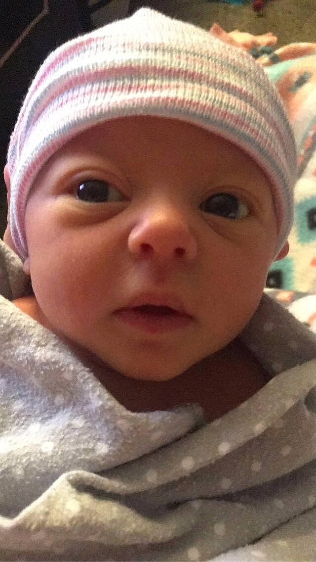 Noel is registered to the contest to win money with this photo: baby, bonnet, cheek, child, chin, close_up, cool, eye, eyebrow, face, facial_expression, forehead, head, headgear, headwear, lip, mouth, nose, person, skin