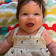 Elena joined the competition — help win amazing prizes! baby, smiling, happy, infant, child, face, hair, eyes, clothing, dress, patterned_blanket, colorful, cute, portrait, laying_down, skin, cheeks, pacifier, indoor, closeup