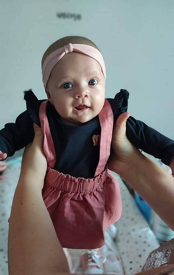 Lily a rejoint le concours — aidez-le/la à gagner de superbes lots ! arm, baby, baby_toddler_clothing, cap, child, comfort, finger, flash_photography, fun, gesture, hand, happy, headwear, nail, person, pink, purple, sitting, skin, sleeve