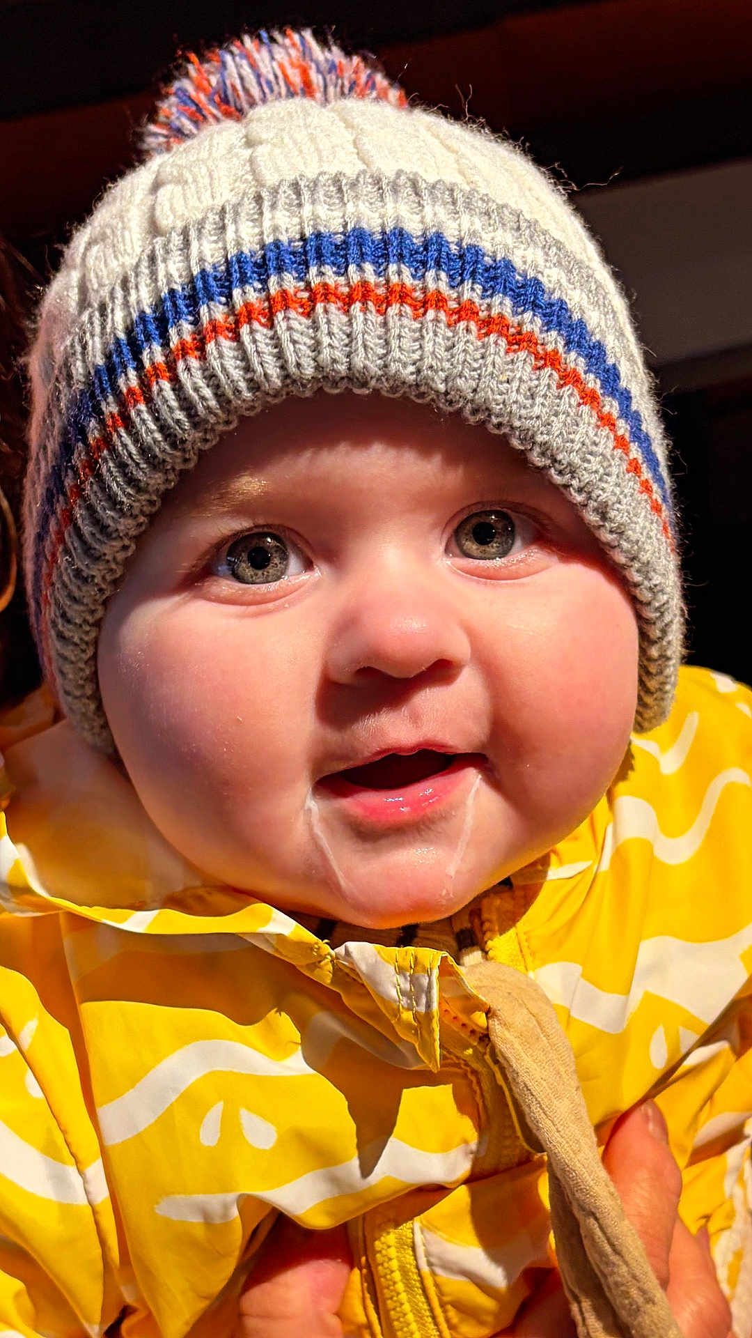 Paul participe au concours pour gagner de l'argent avec cette photo : child, baby, infant, beanie, knit_hat, jacket, yellow, drool, cheeks, close_up, portrait, smiling, eyes, rosy_cheeks, winter_clothing, zipper, hands, candid, indoor, warm_lighting