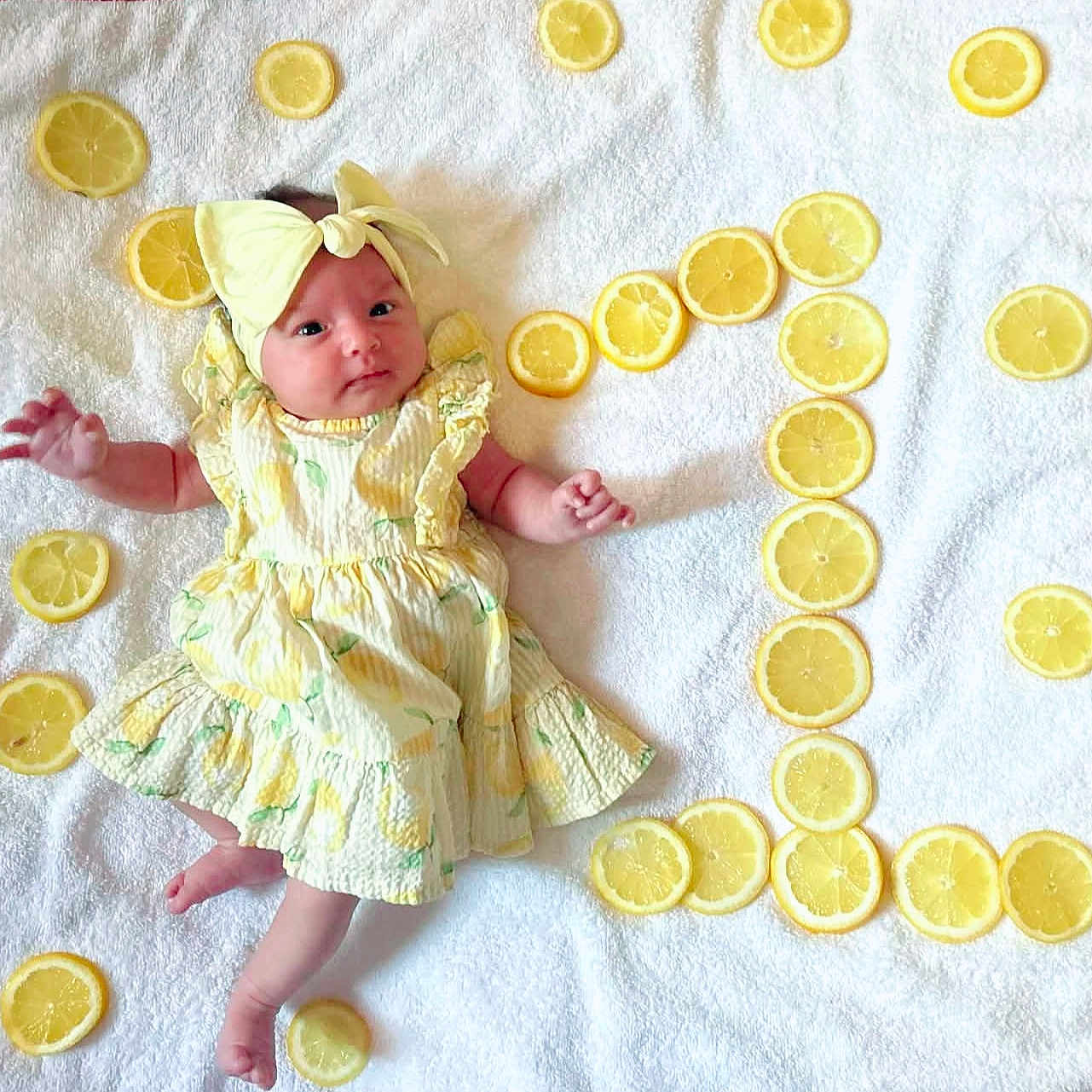 Ariana participe au concours pour gagner de l'argent avec cette photo : arm, baby, blanket, bright, cute, face, flatlay, headband, infant, laying_down, lemon, lemon_slices, newborn, one_number, portrait, props, small_feet, soft_texture, towel, yellow_dress