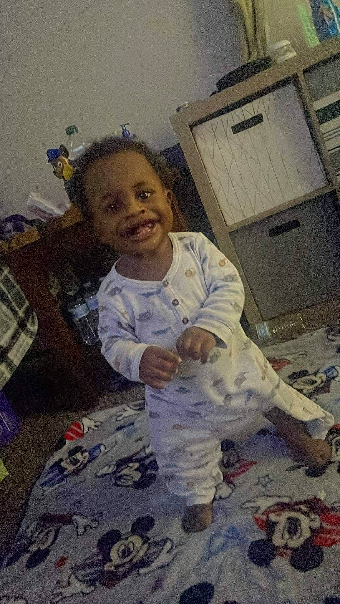 Yon is registered to the contest to win money with this photo: baby, baby_toddler_clothing, cabinetry, chest_of_drawers, child, drawer, facial_expression, floor, flooring, fun, happy, head, joy, linens, person, plaid, room, sitting, smile, standing