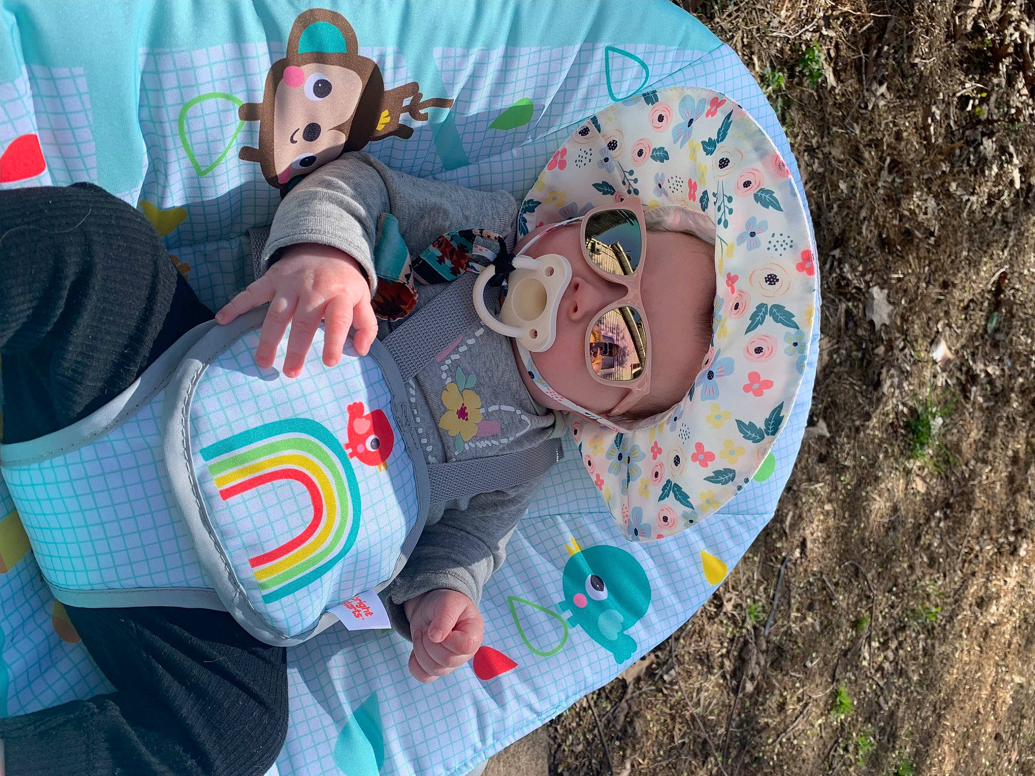 Charlotte is registered to the contest to win money with this photo: baby_toddler_clothing, child, comfort, fun, grass, hand, happy, hat, headgear, headwear, leisure, linens, pattern, person, personal_protective_equipment, recreation, sitting, sneakers, sun_hat, sunglasses