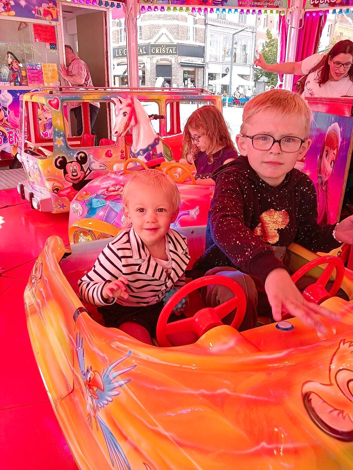 Lenny participe au concours pour gagner de l'argent avec cette photo : amusement_ride, automotive_design, automotive_exterior, bumper, child, event, fun, happy, hood, human_settlement, joy, leisure, motor_vehicle, person, pink, play, playground, recreation, red, smile