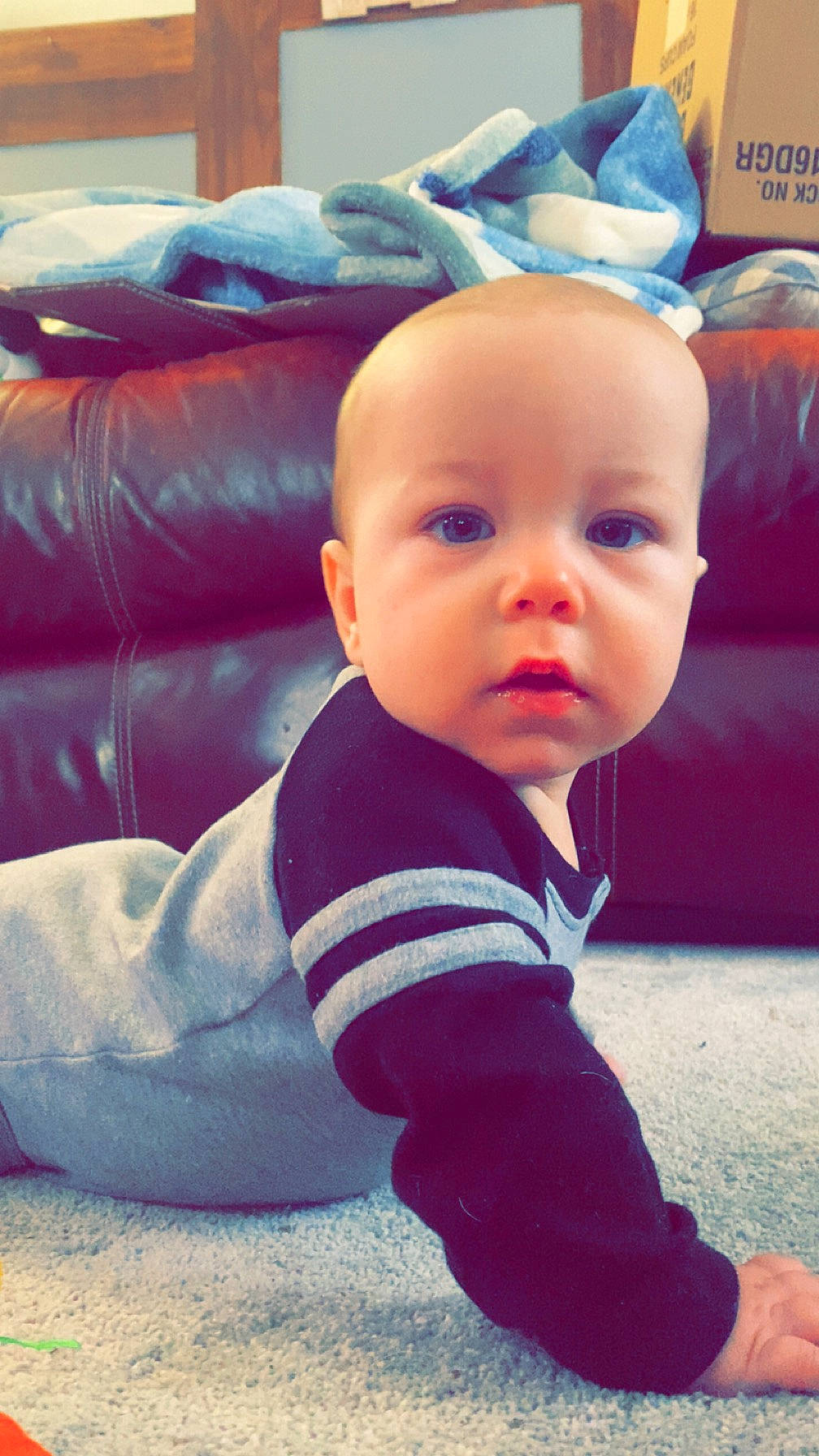 Greyson is registered to the contest to win money with this photo: baby, baby_toddler_clothing, cheek, comfort, cool, electric_blue, eye, facial_expression, flooring, fun, happy, head, mammal, mouth, nose, person, sitting, sleeve, smile, tints_and_shades