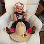 baby, headband, cowboy_boots, cowboy_hat, rubber_duck, white_chair, smiling, shirt, infant, cute, indoors, child, sitting, plush_chair, clothing, footwear, toy, happy, portrait, accessory