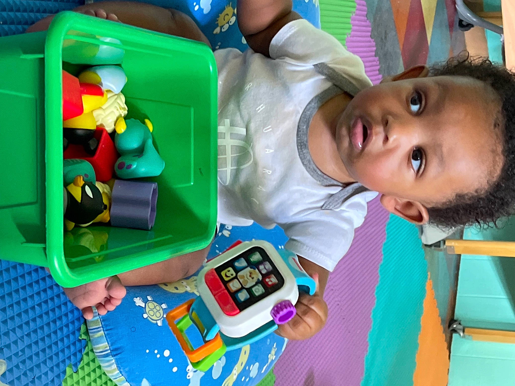 Amiri is registered to the contest to win money with this photo: baby, baby_toys, box, child, communication_device, fun, gadget, games, green, lego, leisure, person, plastic, play, recreation, room, sharing, snapshot, toddler, toy
