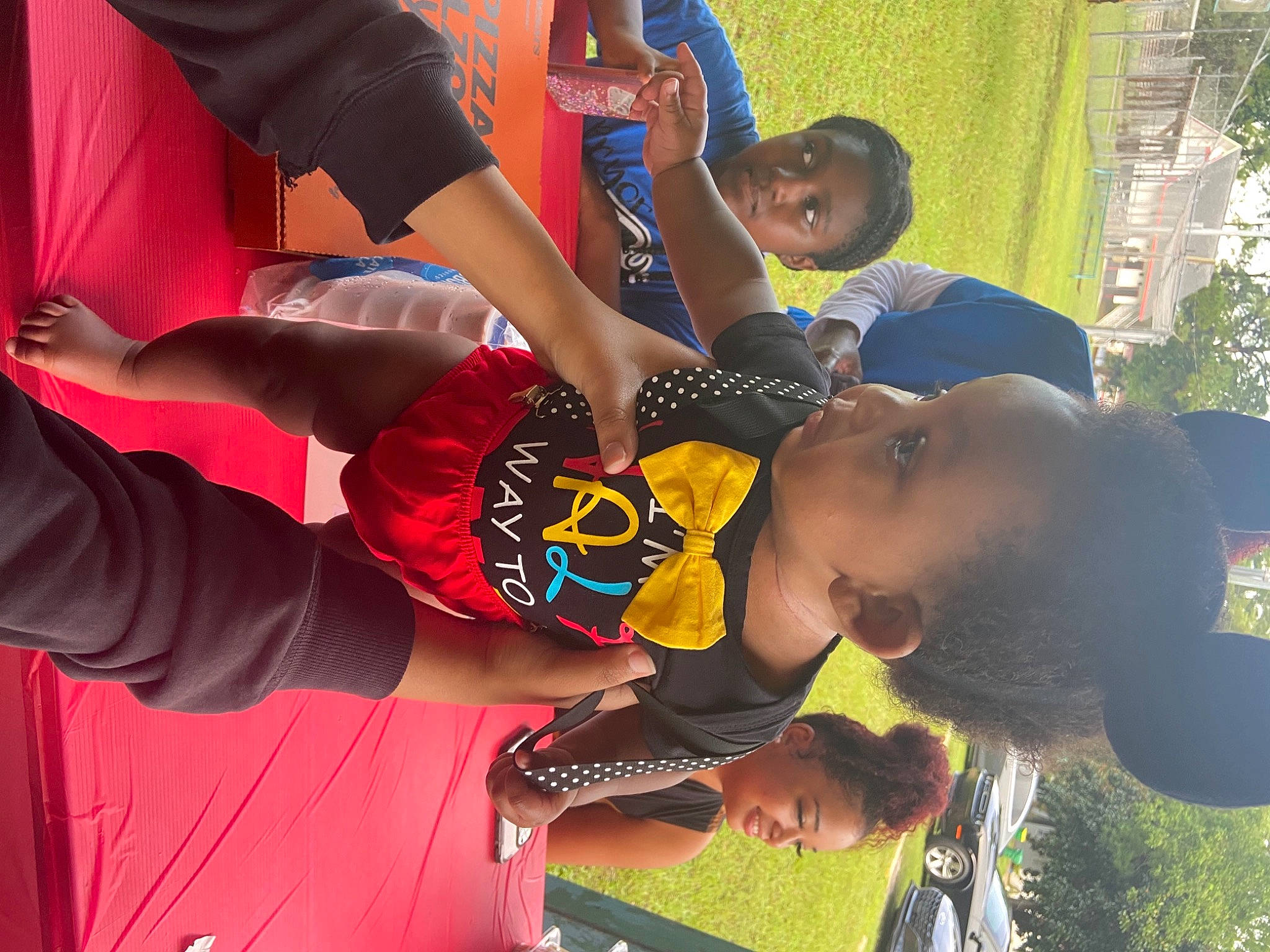 Amiri is registered to the contest to win money with this photo: arm, baby, child, competition_event, elbow, event, fun, games, gesture, grass, happy, joy, leisure, person, plant, player, recreation, shorts, sports_uniform, t_shirt