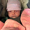 baby, infant, hat, striped_hat, blanket, pink_blanket, face, eyes, nose, mouth, cushion, seat, clothing, child, newborn, portrait, indoors, closeup, soft_texture, warm