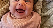 Ravynn is registered to the contest to win money with this photo: baby, smiling, happy, infant, pink_bib, yellow_clothing, quilt, blanket, closeup, face, child, portrait, cute, indoors, warm, cozy, skin, eyes, mouth, expression