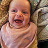 baby, smiling, happy, infant, pink_bib, yellow_clothing, quilt, blanket, closeup, face, child, portrait, cute, indoors, warm, cozy, skin, eyes, mouth, expression
