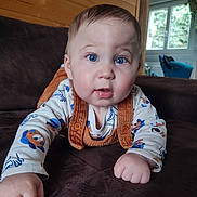 élizio a rejoint le concours — aidez-le/la à gagner de superbes lots ! baby, blue_eyes, cute, couch, indoor, infant, wooden_wall, window, orange_suspender, white_shirt, bear_print, child, face, hands, home, cozy, portrait, expression, furniture, person