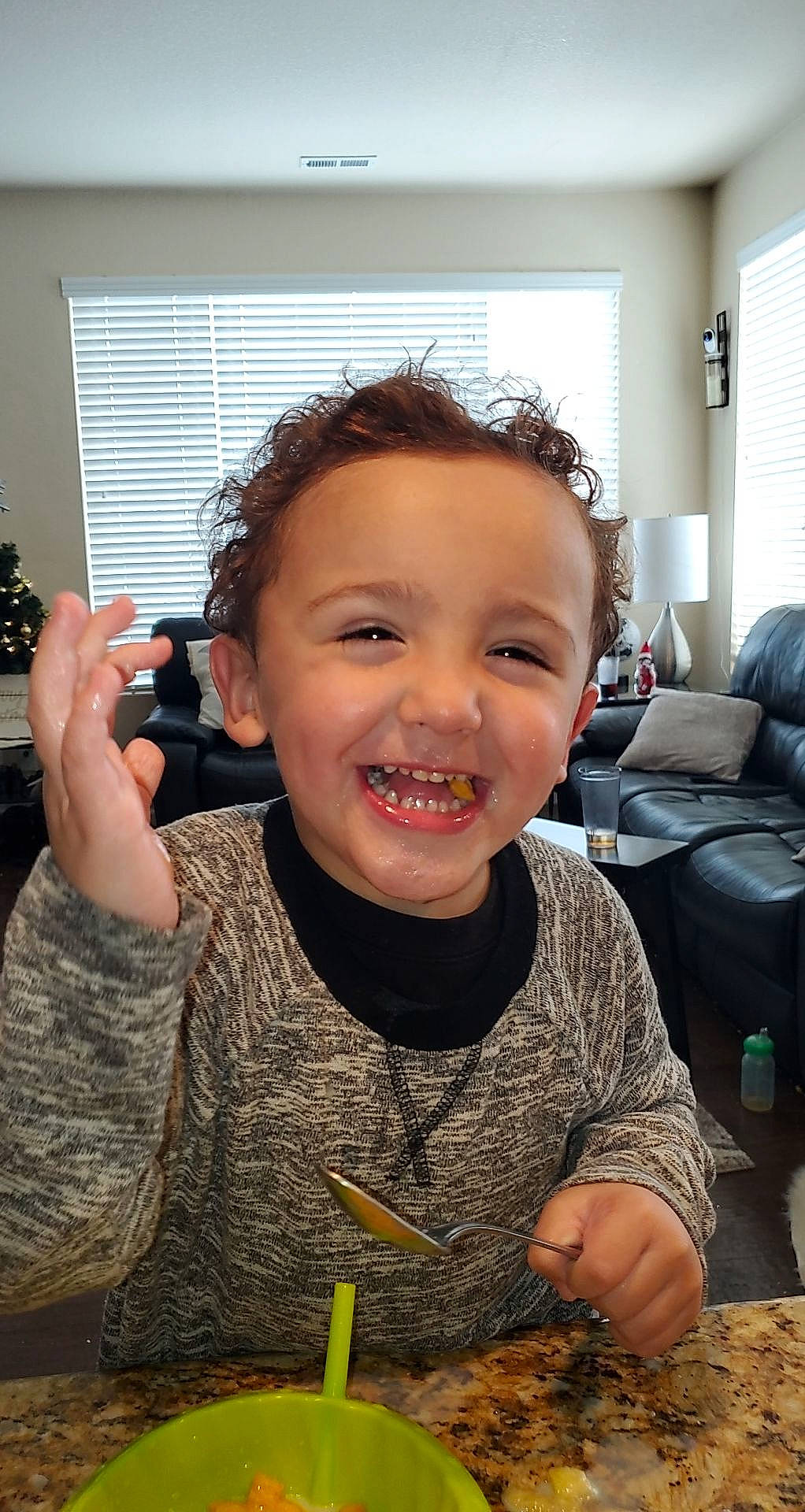 Manny is registered to the contest to win money with this photo: armrest, camera, couch, eating, finger, hand, houseplant, interior_design, joy, living_room, person, pillow, sofa_bed, taste, throw_pillow, thumb, tooth, window_blind, window_covering, window_treatment