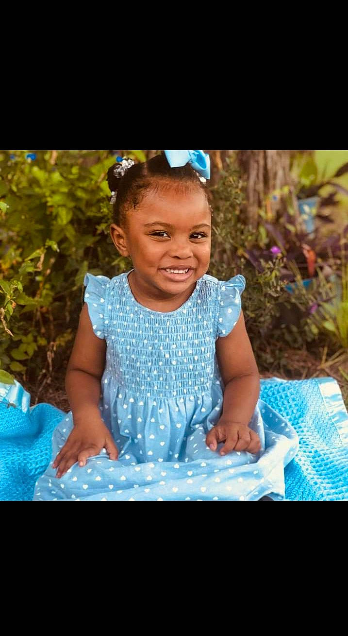 Sariyah is registered to the contest to win money with this photo: baby_toddler_clothing, child, electric_blue, event, flash_photography, formal_wear, fun, grass, happy, iris, jewellery, joy, leisure, magenta, necklace, person, play, recreation, sitting, smile