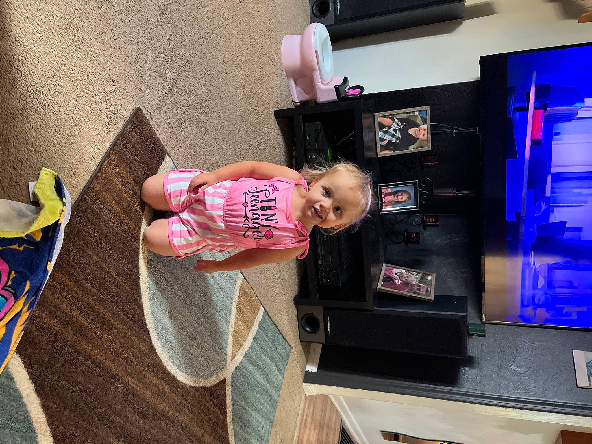 Haisley is registered to the contest to win money with this photo: baby, baby_products, baby_toddler_clothing, child, display_device, flat_panel_display, flooring, fun, house, joy, lcd_tv, led_backlit_lcd_display, machine, magenta, person, room, television, television_set, toddler, wood